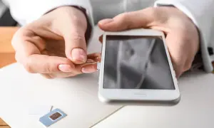 Maintenant, découvrez comment ouvrir le tiroir carte sim sans outil. Une main insère un trombone dans le téléphone.