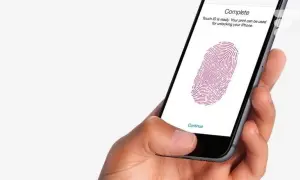 Main d'une personne tenant un iPhone 13, configurant le Touch ID pour déverrouiller son appareil.