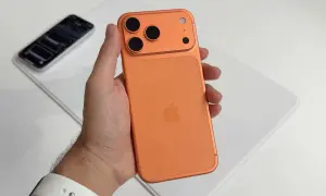 Maintenant, un **iphone avec 4 caméras** orange est tenu dans une main.