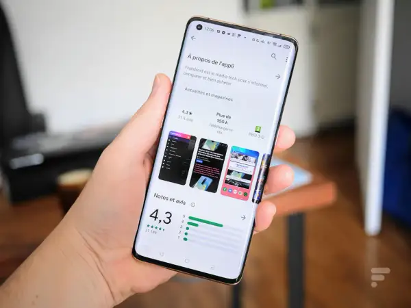 Main tenant un smartphone Samsung, affichant la page d'une application sur le Play Store, prêt à mettre à jour une application.